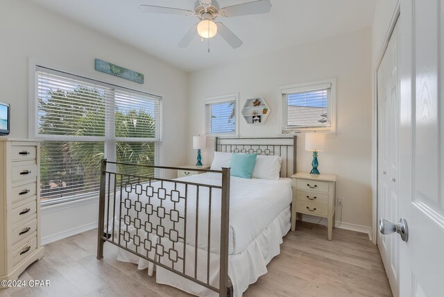 bedroom with multiple windows, ceiling fan, and light wood-type flooring