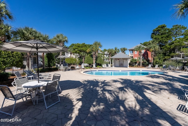 view of swimming pool featuring an outbuilding and a patio