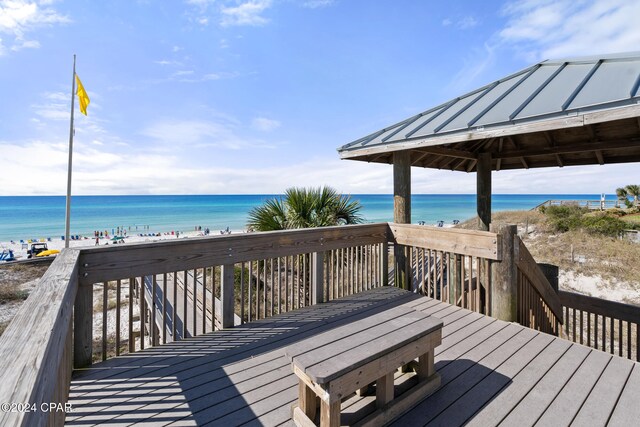 wooden deck featuring a gazebo, a water view, and a view of the beach