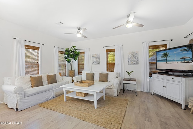 living room with light hardwood / wood-style floors, ceiling fan, and a healthy amount of sunlight