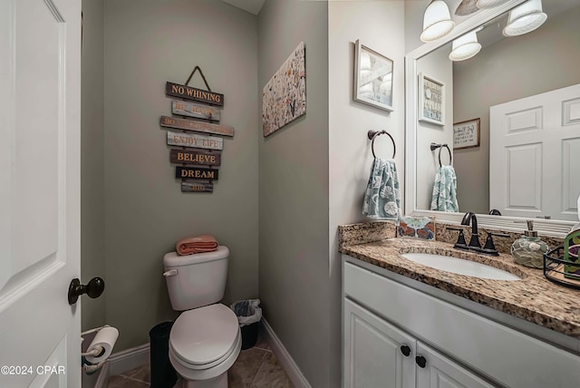 bathroom with toilet, vanity, and tile patterned flooring