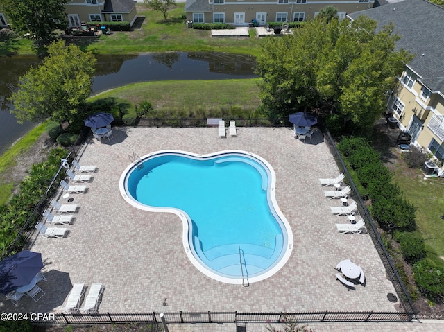 view of swimming pool with a patio area and a water view