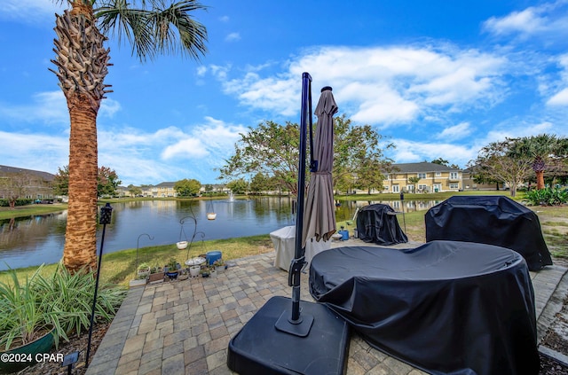 view of patio / terrace with grilling area and a water view