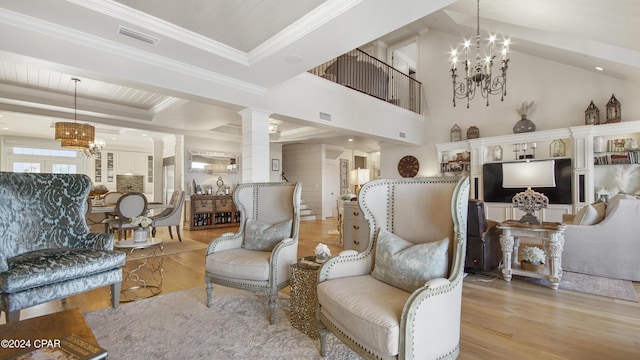 living room with visible vents, a notable chandelier, wood finished floors, decorative columns, and a raised ceiling