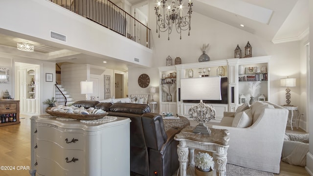 living area with visible vents, an inviting chandelier, ornamental molding, and light wood finished floors