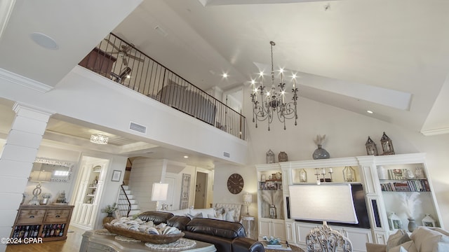 living room with stairs, an inviting chandelier, visible vents, and ornate columns