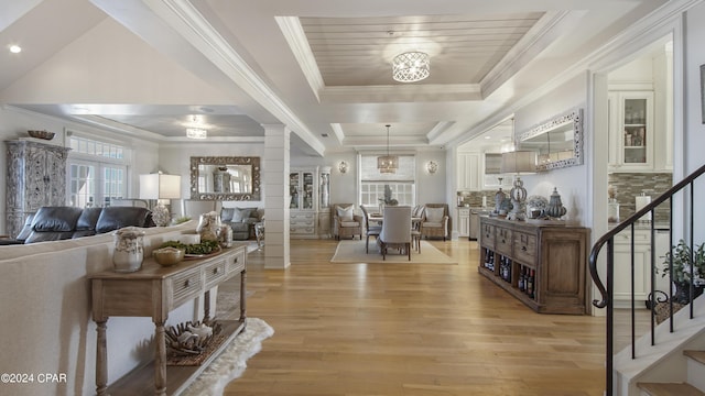 interior space with stairway, crown molding, light wood-type flooring, and decorative columns