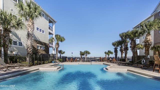 community pool featuring a patio and fence