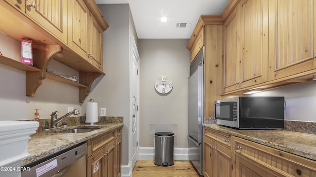 kitchen with visible vents, a sink, stone counters, appliances with stainless steel finishes, and open shelves