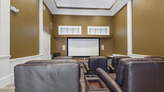 home theater with a tray ceiling, visible vents, a wainscoted wall, and ornamental molding