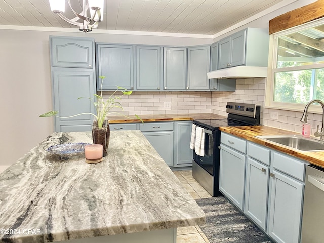 kitchen featuring backsplash, ornamental molding, sink, light tile patterned floors, and appliances with stainless steel finishes