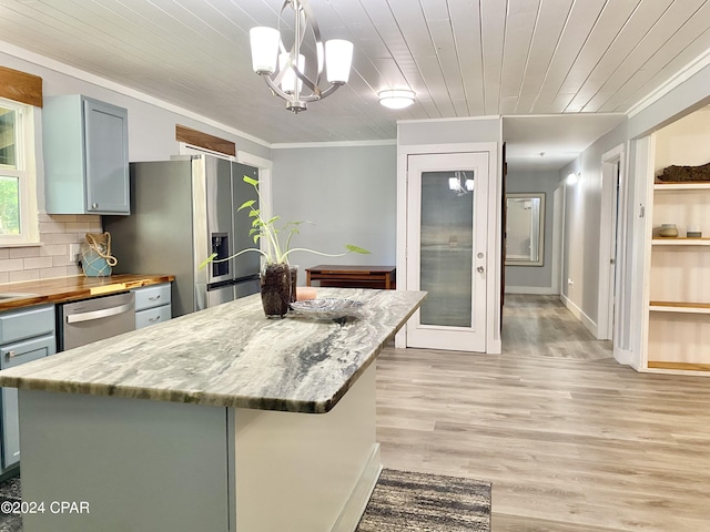 kitchen featuring a kitchen island, light hardwood / wood-style flooring, decorative light fixtures, and stainless steel appliances