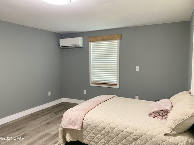 bedroom featuring an AC wall unit and hardwood / wood-style floors