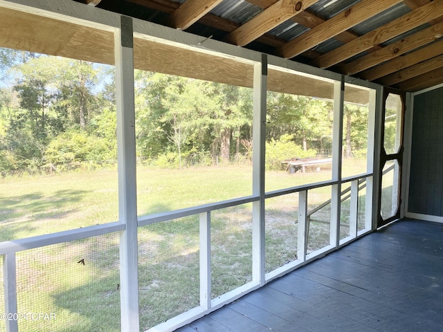 unfurnished sunroom featuring beam ceiling