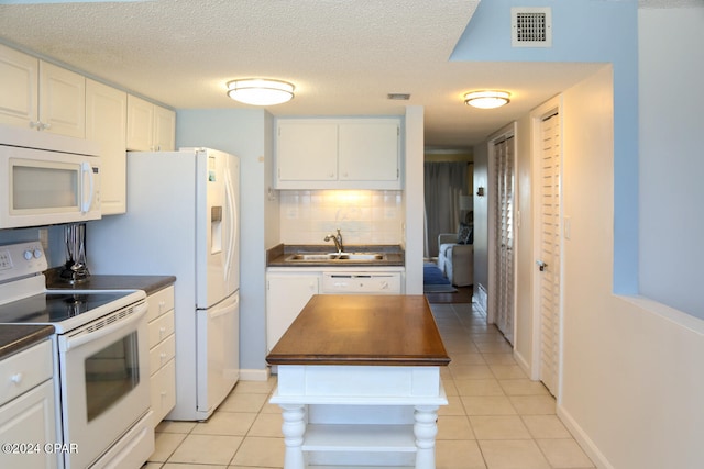 kitchen featuring sink, white cabinetry, white appliances, and light tile patterned floors