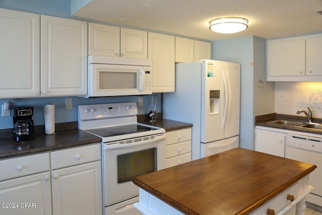 kitchen with white appliances, sink, a textured ceiling, white cabinets, and decorative backsplash