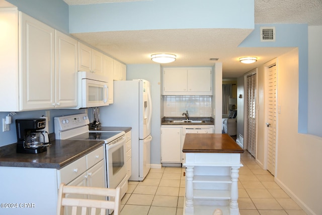 kitchen featuring white cabinets, white appliances, and light tile patterned floors