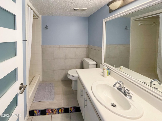 bathroom with a textured ceiling, toilet, tile walls, a shower with curtain, and vanity