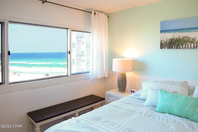 bedroom with a textured ceiling and a water view