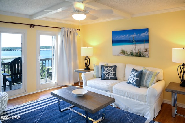 living room with a textured ceiling, a water view, and hardwood / wood-style flooring