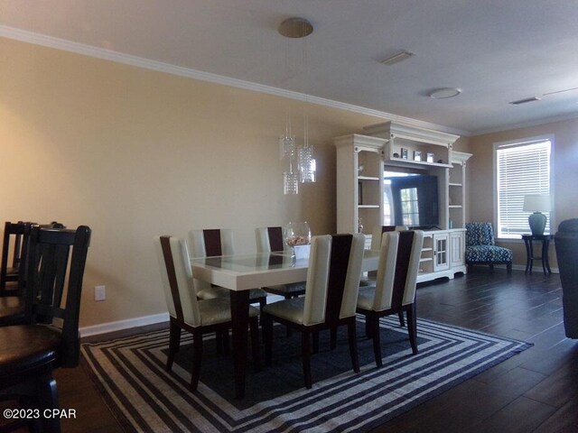 dining space with crown molding and dark wood-type flooring