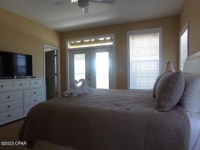 bedroom with multiple windows, access to exterior, and ceiling fan