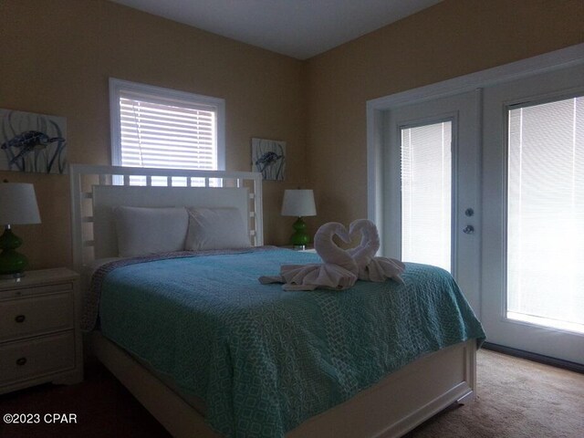 carpeted bedroom featuring multiple windows and french doors