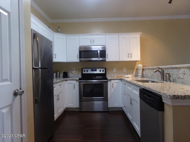 kitchen featuring light stone counters, stainless steel appliances, kitchen peninsula, and white cabinets