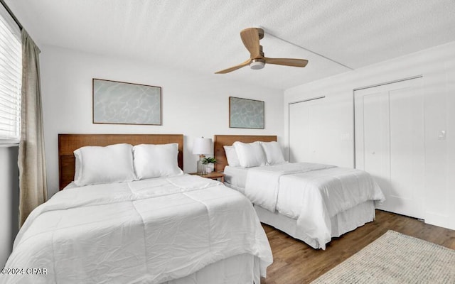 5801 Thomas Dr Unit 501, Panama City, FL 32408 - bedroom with two closets, a ceiling fan, wood finished floors, and a textured ceiling