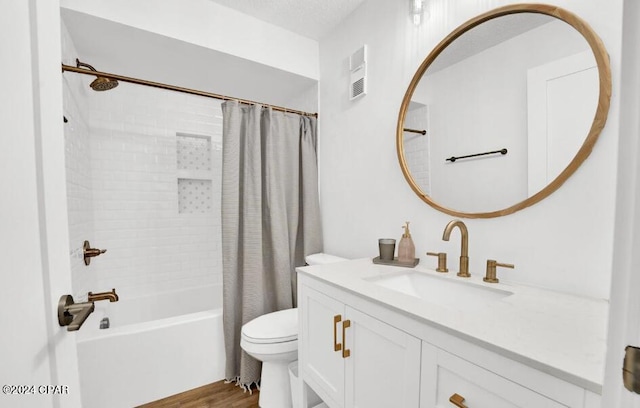 full bathroom with a textured ceiling, wood-type flooring, toilet, shower / bath combo with shower curtain, and vanity