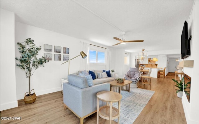 5801 Thomas Dr Unit 501, Panama City, FL 32408 - living room featuring light wood-type flooring, a ceiling fan, baseboards, a textured ceiling, and a chandelier