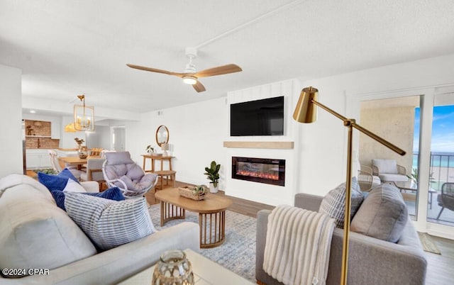 living room featuring wood-type flooring and ceiling fan with notable chandelier