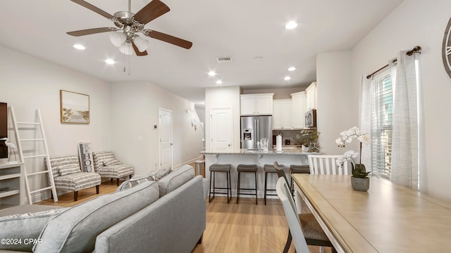 living room featuring light hardwood / wood-style floors and ceiling fan