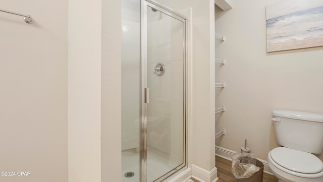 bathroom featuring hardwood / wood-style floors, toilet, and walk in shower