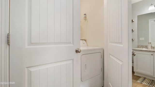 laundry area featuring washer / dryer and light hardwood / wood-style flooring