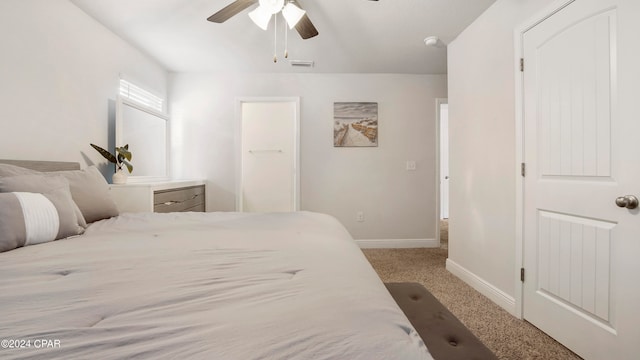 carpeted bedroom with a closet, a spacious closet, and ceiling fan