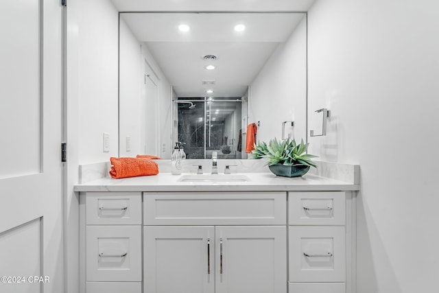 bathroom featuring vanity and a shower with shower door