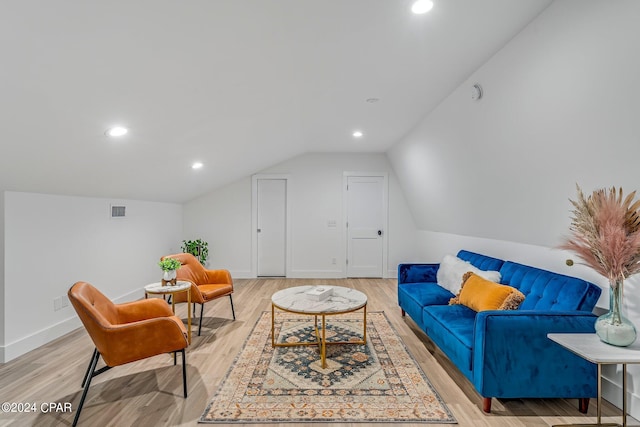 living room with light hardwood / wood-style floors and lofted ceiling