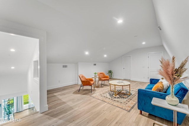 living room featuring light hardwood / wood-style floors and vaulted ceiling