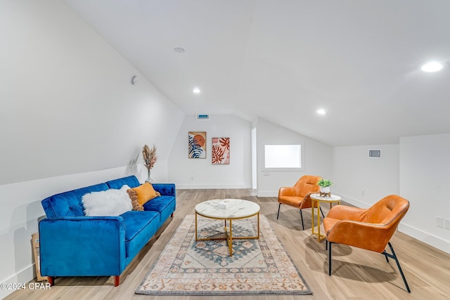 living area with light hardwood / wood-style flooring and vaulted ceiling