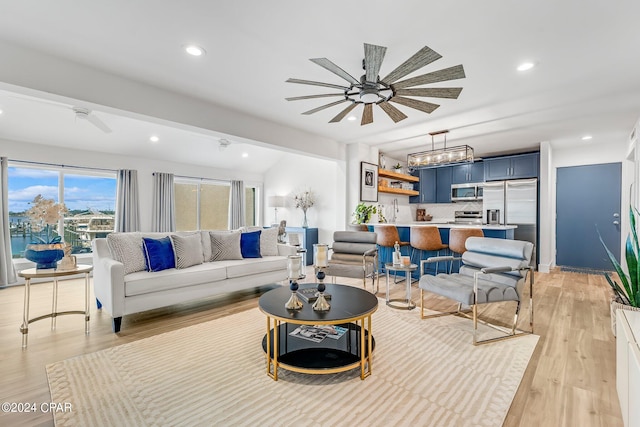 living room with light hardwood / wood-style floors, sink, and ceiling fan