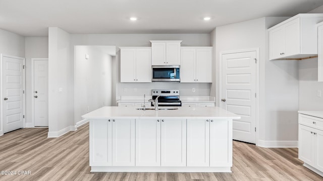 kitchen featuring light hardwood / wood-style flooring, an island with sink, stainless steel appliances, and sink