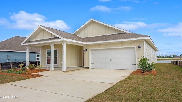 view of front facade with a front yard, a garage, and covered porch