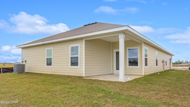 rear view of house featuring cooling unit, a yard, and a patio