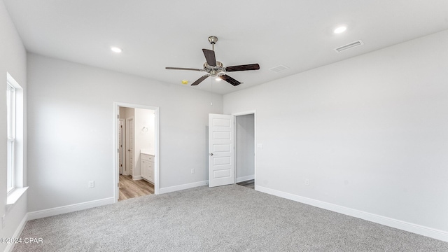 unfurnished bedroom with ensuite bathroom, ceiling fan, and light carpet