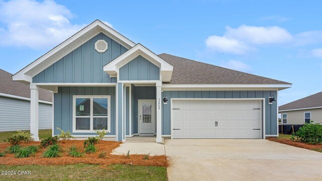 ranch-style house featuring a shingled roof, board and batten siding, an attached garage, and concrete driveway