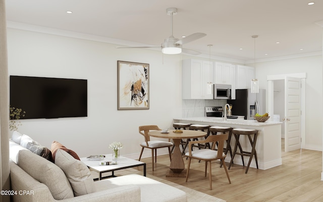 living room with ceiling fan, crown molding, light hardwood / wood-style flooring, and sink