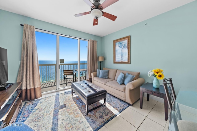 living room with ceiling fan, light tile patterned floors, and a water view