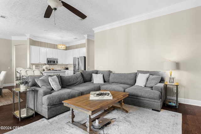 living room with ceiling fan, a textured ceiling, dark hardwood / wood-style flooring, and ornamental molding