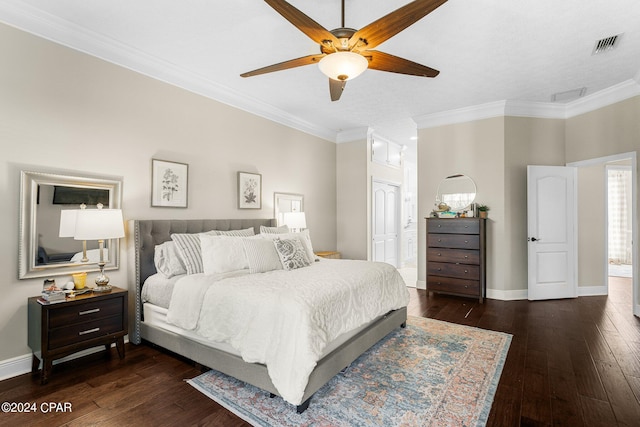 bedroom with crown molding, ceiling fan, ensuite bathroom, and dark hardwood / wood-style flooring